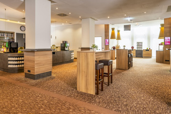 Weitläufiges Tagungsfoyer mit Säulen, Buffetanrichten und kleiner Bar 