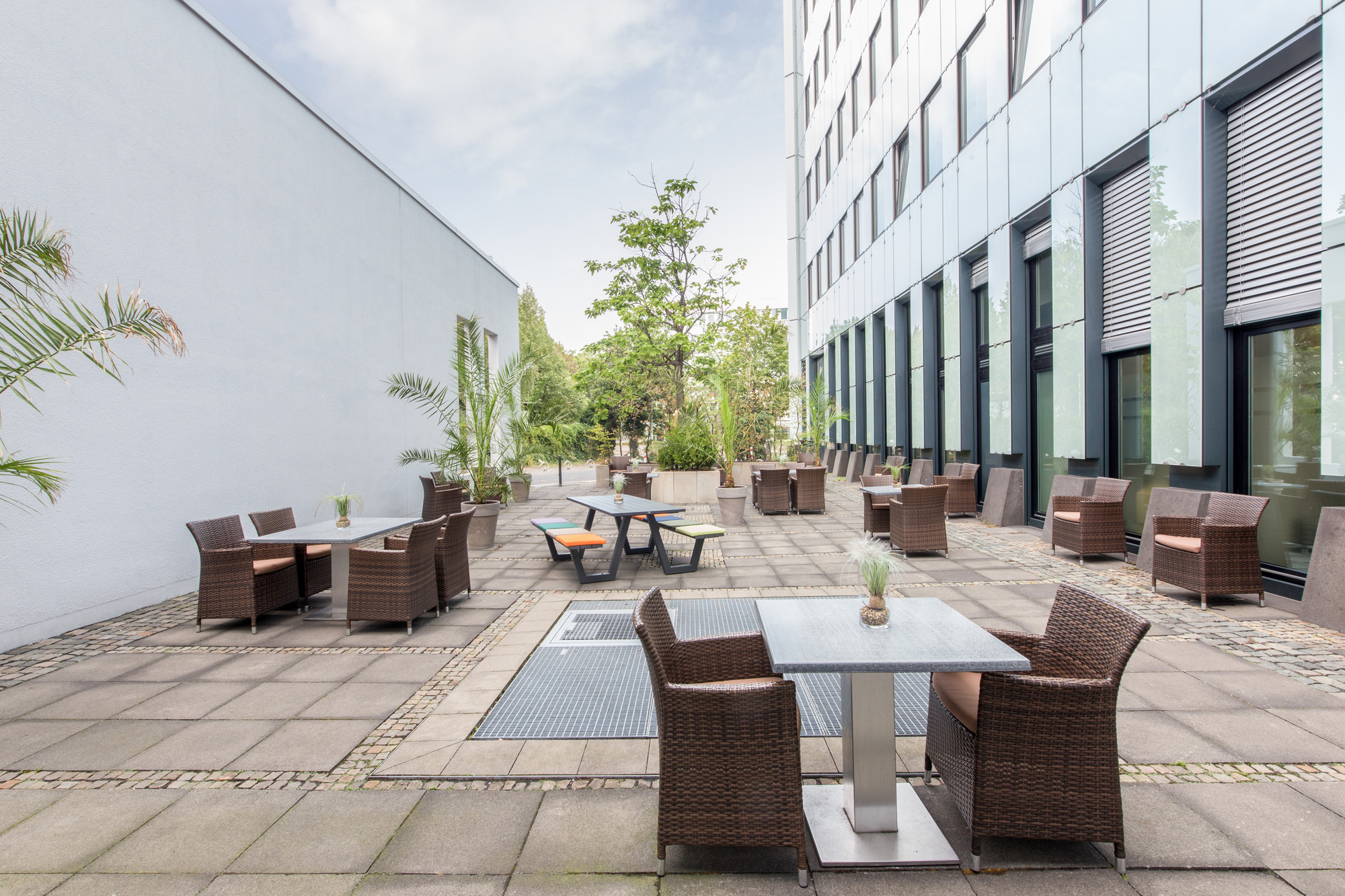 Tagungsterrasse mit Tischgruppen und einigen Pflanzen