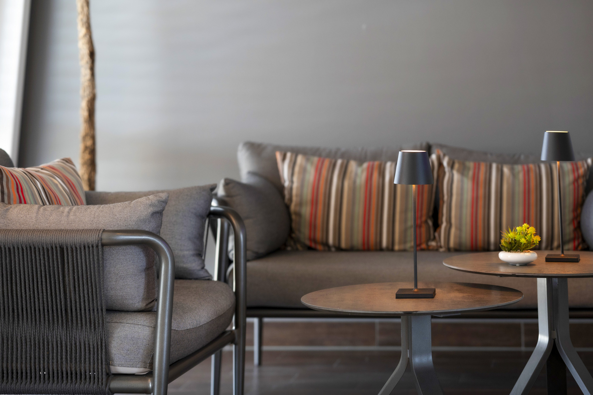 Ruhebereich mit Sofa und kleinen, runden Tischen und Tischbeleuchtung